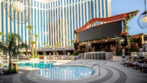 Tao beach club with a pool and chairs with palm trees surrounding it at the venetian